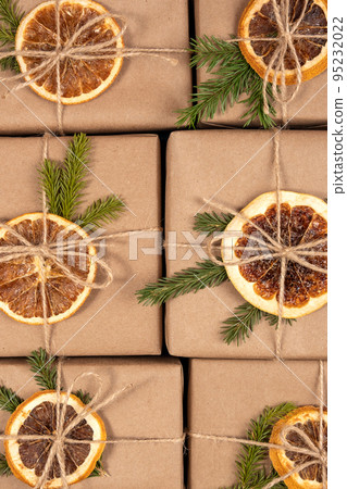 Christmas or New Year's background from boxes in craft paper with dried oranges, spruce branches and twine close-up. Concept Zero waste, eco friendly Merry Christmas. Top view Flat lay Christmas or New Year's background from boxes in craft paper with dried oranges, spruce branches and twine close-up. Concept Zero waste, eco friendly Merry Christmas. Top view Flat lay 95232022