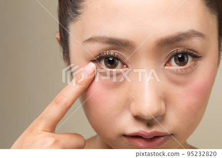 一個女人指著眼睛。 95232820