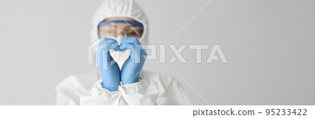 Doctor in protective suit makes heart gesture with hands 95233422