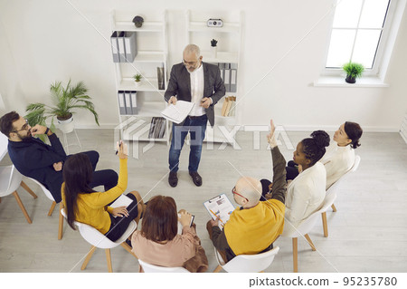 Team of employees having a meeting, discussing something, and asking their manager questions Team of employees having a meeting, discussing something, and asking their manager questions 95235780