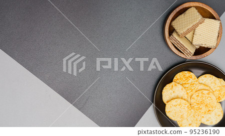 Flat lay of snack, Crispy potato chip and wafer in various containers on gray background 95236190