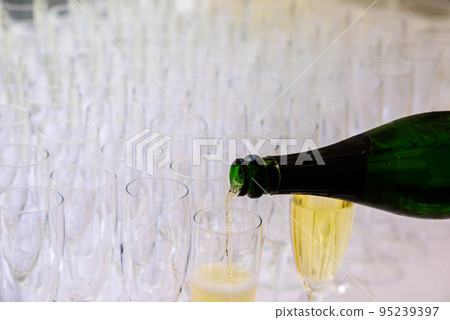 pooring champagne into a champagne flute 95239397