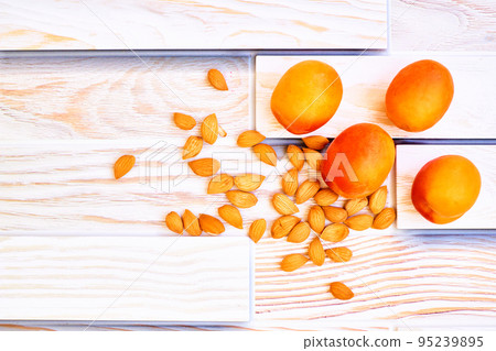 Fresh ripe apricot fruits with kernels isolated on wood background 95239895