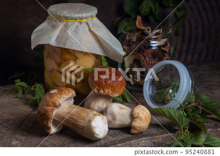 Porcini mushroom commonly known as Boletus Edulis, glass jar with canned mushrooms and glass jar with dry mushrooms on vintage wooden background.. Porcini mushroom commonly known as Boletus Edulis, glass jar with canned mushrooms and glass jar with dry mushrooms on vintage wooden background.. 95240881