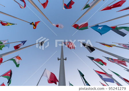 Doha, Qatar - October 9, 2022: The Flag Plaza, displays 119 flags from countries with authorized diplomatic missions, including flags of the European Union, the United Nation and the GCC. 95241279