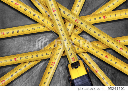 Large Group of Tape Measures on a Silver Metal Background 95241301