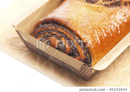 poppy seed strudel on a brown baking paper isolated on white poppy seed strudel on a brown baking paper isolated on white 95241634