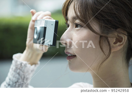 用膠卷相機拍攝城市景觀的年輕女子 95242958