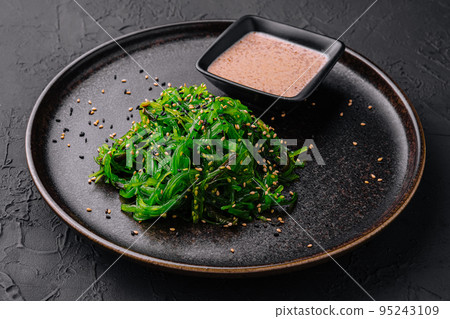 Wakame seaweed salad with sesame seeds on black plate Wakame seaweed salad with sesame seeds on black plate 95243109