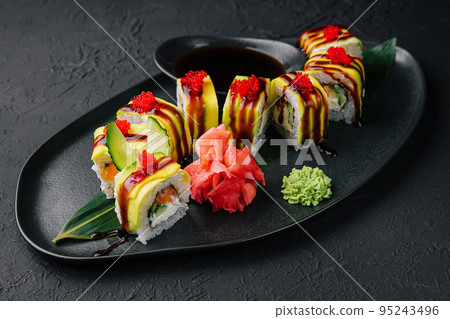 Green dragon sushi roll with eel on black stone Green dragon sushi roll with eel on black stone 95243496