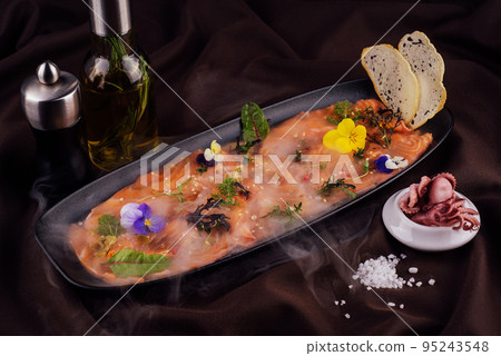 Smoked salmon carpaccio and octopus with white smoke of liquid nitrogen Smoked salmon carpaccio and octopus with white smoke of liquid nitrogen 95243548