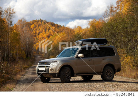 SUV on scenic autumn road in the forest 95243841