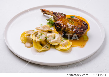 tomahawk steak and ravioli on plate tomahawk steak and ravioli on plate 95244531