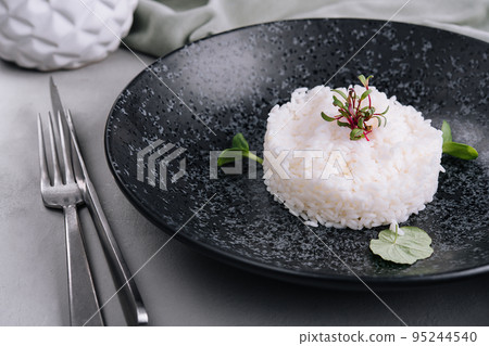 Portion of classic italian risotto on black plate Portion of classic italian risotto on black plate 95244540