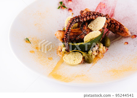 fried octopus with avocado on plate 95244541