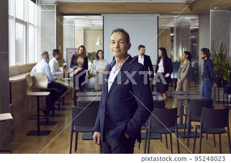 Successful adult Caucasian man manager in meeting room in front of business partners and employees 95248023