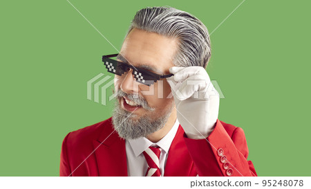 Portrait of adult bearded man in funny thug life spectacles and red Christmas suit 95248078