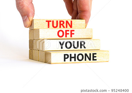 Turn off your phone symbol. Concept words Turn off your phone on wooden blocks. Beautiful white table white background. Businessman hand. Business psychological turn off your phone concept. Copy space Turn off your phone symbol. Concept words Turn off your phone on wooden blocks. Beautiful white table white background. Businessman hand. Business psychological turn off your phone concept. Copy space 95248400