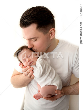 Close up portrait of young father and newborn baby. Father holds in his arms, gently hugs, kisses a beautiful newborn daughter. The concept of love, happy fatherhood. Photo on a white background. 95248666