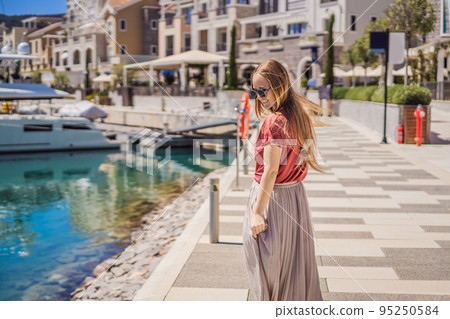 Woman tourist enjoying the views of Architecture and luxury yachts in Lustica Bay, Montenegro. Travel around Montenegro concept. Go Everywhere Woman tourist enjoying the views of Architecture and luxury yachts in Lustica Bay, Montenegro. Travel around Montenegro concept. Go Everywhere 95250584