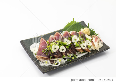 Seared bonito with green onions and garlic_white background 95250605