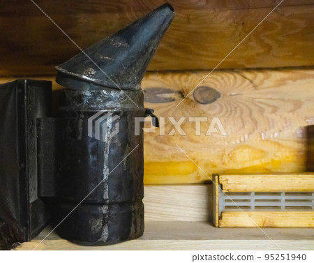 smoker for bees on a wooden background. Breeding bees and extracting honey. Copy space for text 95251940