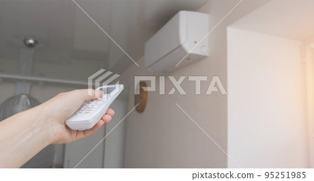 Management of a wall split system in the office using a control panel. Air conditioner in the room. Modern air conditioning, freshness and coolness. Copy space for text Management of a wall split system in the office using a control panel. Air conditioner in the room. Modern air conditioning, freshness and coolness. Copy space for text 95251985