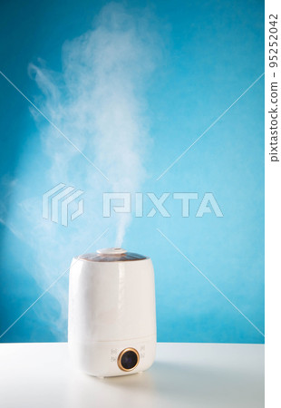 Modern air humidifier on a blue background. Humidification in the room, close-up 95252042