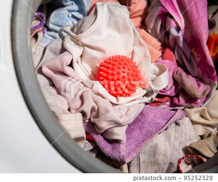 Red ball for washing clothes in the washing machine. Improving the quality of washing, close-up 95252328