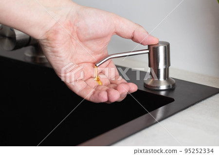 Dispenser for soap and hand hygiene. Modern dispenser built into the kitchen sink, close-up 95252334