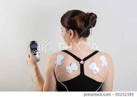 medical electric acupuncture massager on the body of a girl. Fat burning and health promotion. Physiotherapy, close-up 95252393