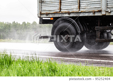 Truck wheel on a wet slippery road in the rain. The concept of danger on the road in bad rainy weather. Tire grip on the road. Copy space for text Truck wheel on a wet slippery road in the rain. The concept of danger on the road in bad rainy weather. Tire grip on the road. Copy space for text 95252404