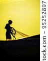 Silhouette of a fisherman at sunset 95252897
