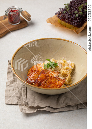 Portion of fettuccine pasta with grilled chicken 95253292