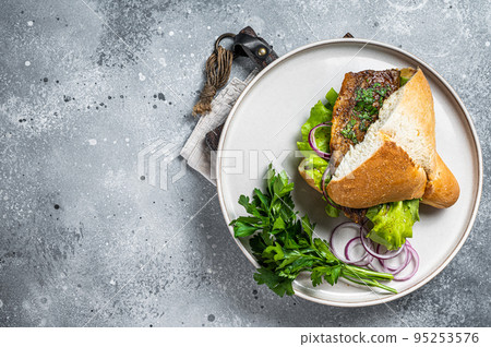 Balik Ekmek Turkish fish sandwich with grilled mackerel fillet in a bun. Gray background. Top view. Copy space Balik Ekmek Turkish fish sandwich with grilled mackerel fillet in a bun. Gray background. Top view. Copy space 95253576