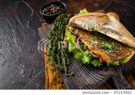 Turkish Street Food Balik Ekmek, fish sandwich with grilled mackerel fillet in a bun. Dark background. Top view. Copy space 95253602