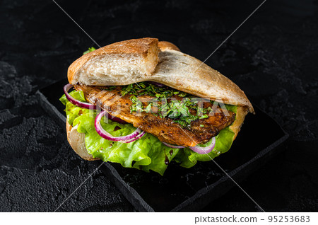 Turkish fish sandwich with grilled mackerel fillet Balik Ekmek. Black background. Top view Turkish fish sandwich with grilled mackerel fillet Balik Ekmek. Black background. Top view 95253683