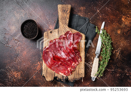 Turkish pastrami (kayseri pastirma), dried beef meat with spices. Dark background. Top view 95253693