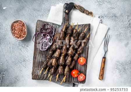 Chicken hearts grilled on skewers with herbs and spices. White background. Top view Chicken hearts grilled on skewers with herbs and spices. White background. Top view 95253733