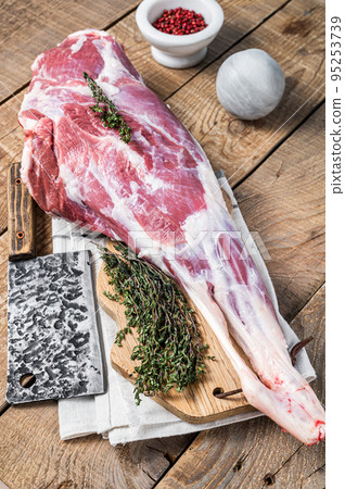 Butcher board with Raw lamb mutton leg with herbs. Wooden background. Top view 95253739