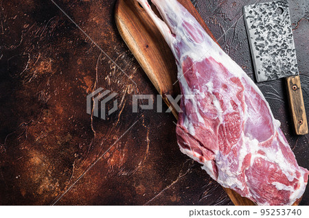 Raw whole lamb leg thigh on butcher board. Dark background. Top view. Copy space Raw whole lamb leg thigh on butcher board. Dark background. Top view. Copy space 95253740