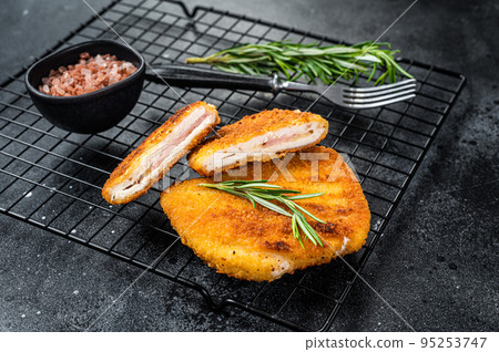 Schnitzel Cordon bleu fillet cutlet with ham and cheese. Black background. Top view 95253747