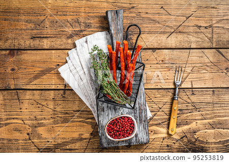 Homemade small thin kabanos sausages in a basket. Wooden background. Top view 95253819