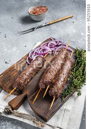 Grilled kofta kofte shish kebab from mince lamb and beef meat on Skewer. Gray background. Top view Grilled kofta kofte shish kebab from mince lamb and beef meat on Skewer. Gray background. Top view 95253910