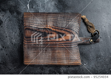 Cooking background with old empty cutting board. Black background. Top view. Copy space Cooking background with old empty cutting board. Black background. Top view. Copy space 95254034