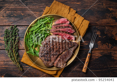 BBQ dinner with top sirloin beef steak and salad on a plate. Wooden background. Top view 95254041