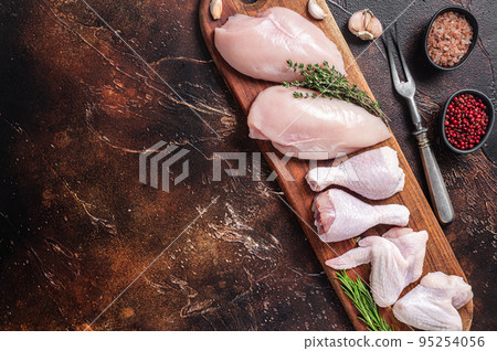 Raw chicken meat, assortment of parts - drumstick, breast fillet, wings, thigh with spices. Dark background. Top view. Copy space Raw chicken meat, assortment of parts - drumstick, breast fillet, wings, thigh with spices. Dark background. Top view. Copy space 95254056
