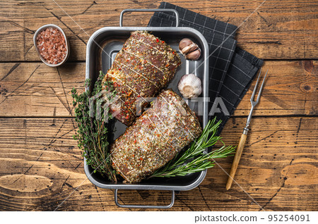 Raw Rolled pork belly italian Porchetta with herbs and spices. Wooden background. Top view Raw Rolled pork belly italian Porchetta with herbs and spices. Wooden background. Top view 95254091