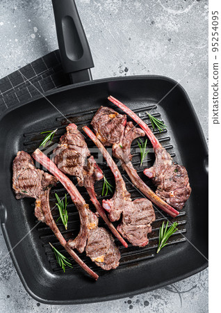 Fried on a grill skillet lamb cutlet steak, mutton rib chop. Gray background. Top view Fried on a grill skillet lamb cutlet steak, mutton rib chop. Gray background. Top view 95254095