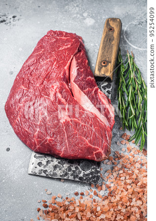 Butcher board with raw prime beef steak top sirloin or rump with pink salt and rosemary. Gray background. Top view 95254099